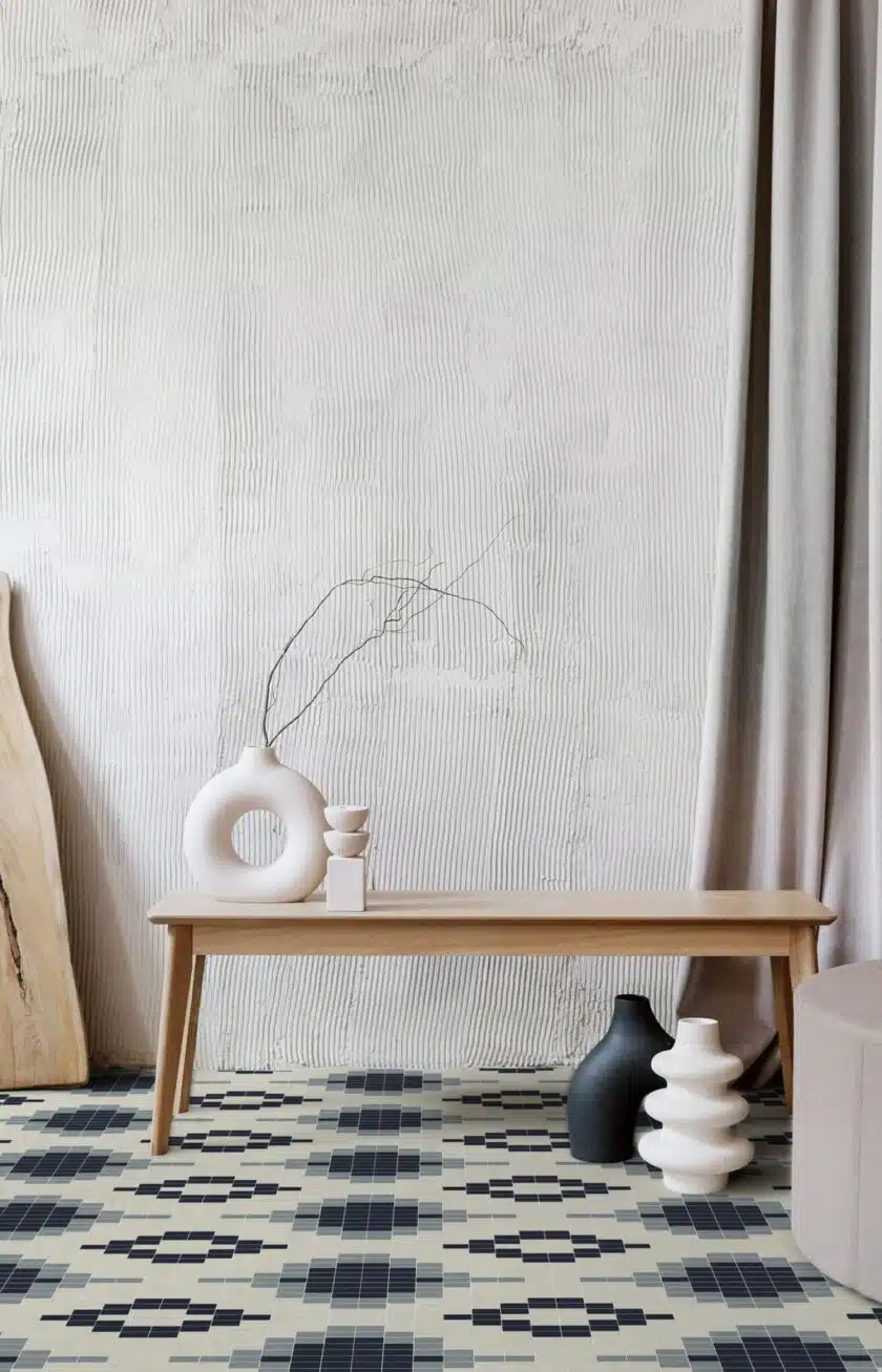 Cropped view of ceramic vases with branches and wooden board in room with beige textured walls. Still life composition. Cozy flat design idea